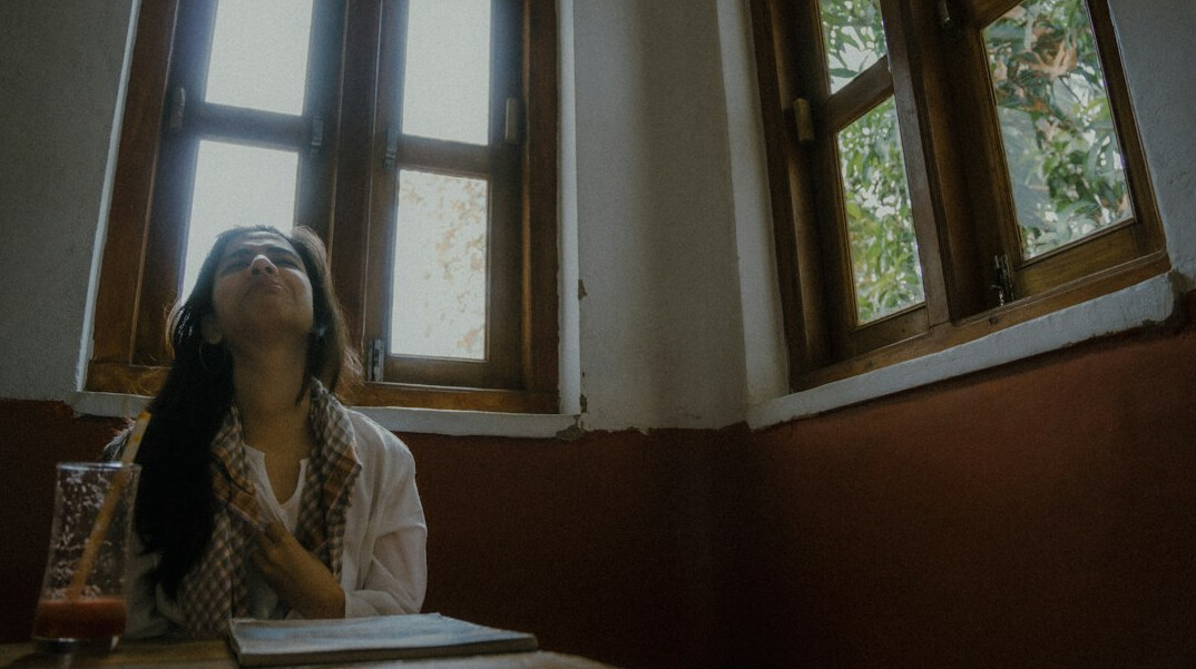 woman reading book by window